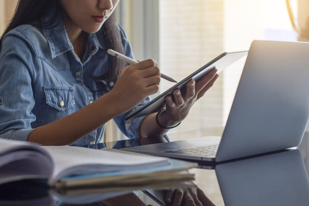 young woman operates tablet with pen