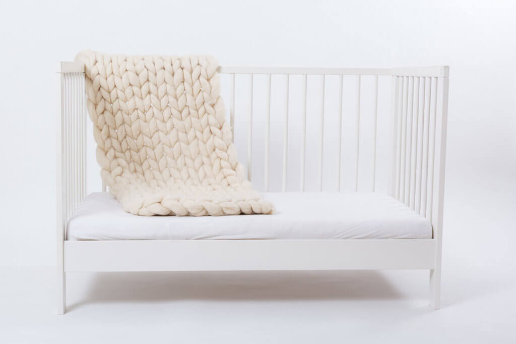 White baby cot with cot rail