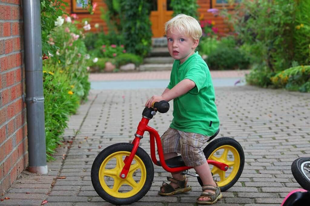 Boy sitting upright on balance bike 