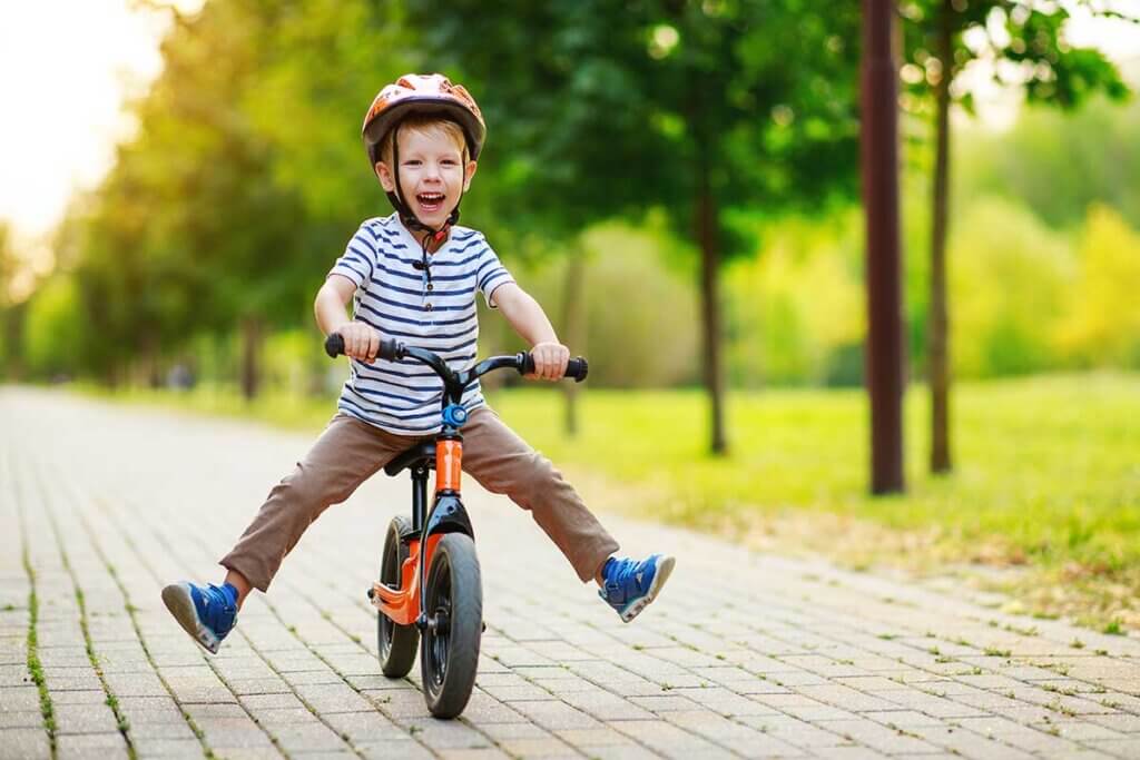 Little boy rides through the park
