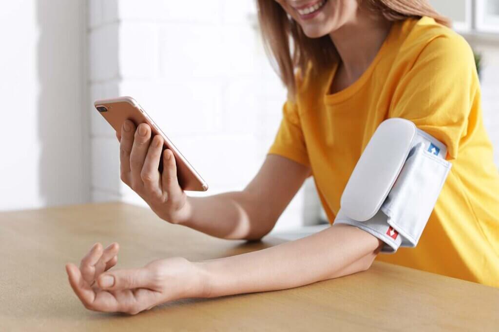 woman checks blood pressure via smartphone connection