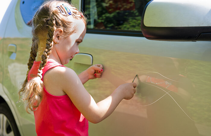 child-scratches-car