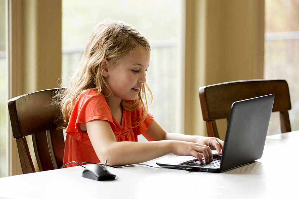 girl works with chromebook at home