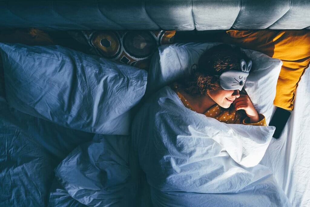 clock radio woman sleeps with mask in bed
