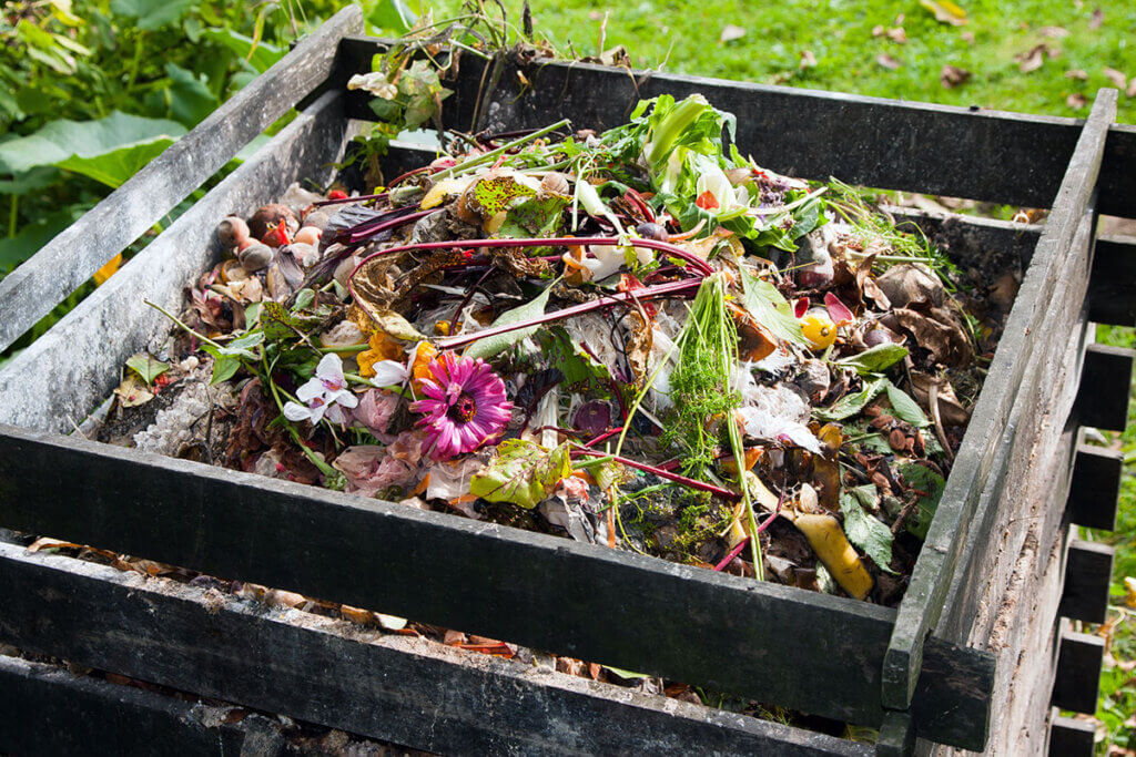 A filled composter in the garden