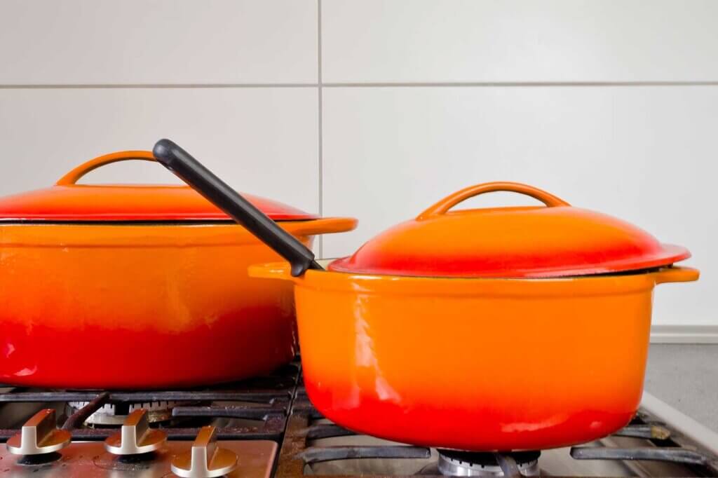 two orange pots standing on cooker