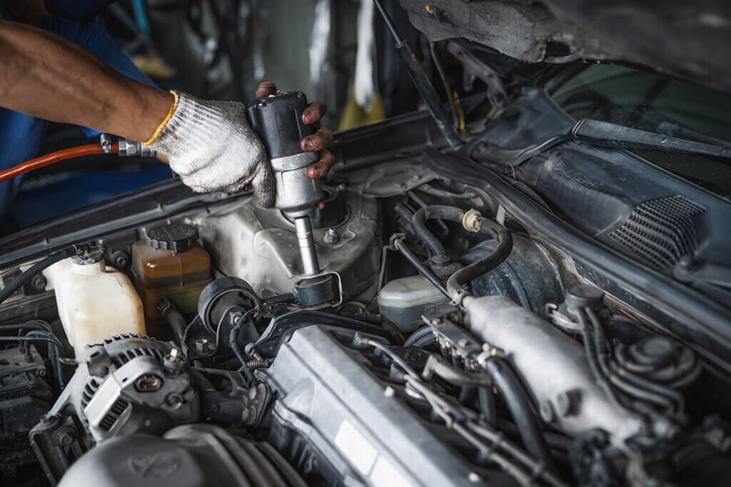 Car mechanic with impact wrench