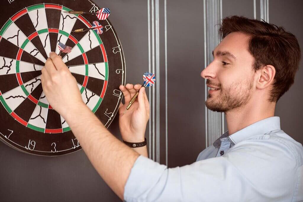 man_pulls_darts_from_board