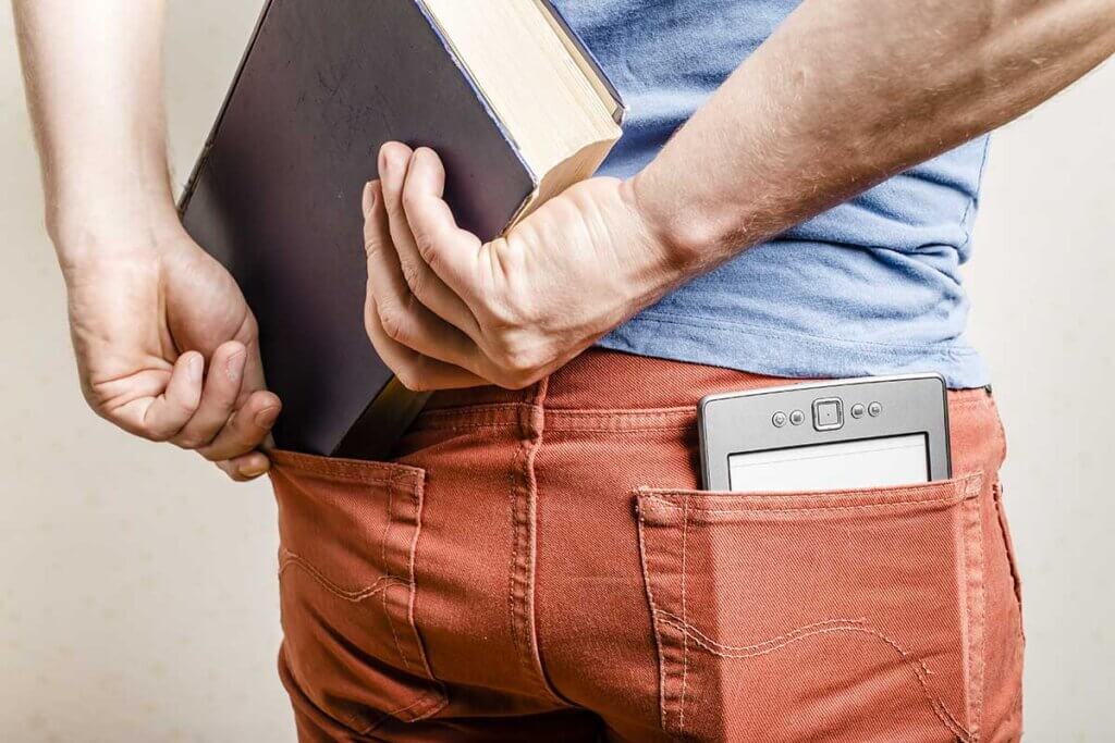 man with ebook reader in his pocket tries to plug in real book