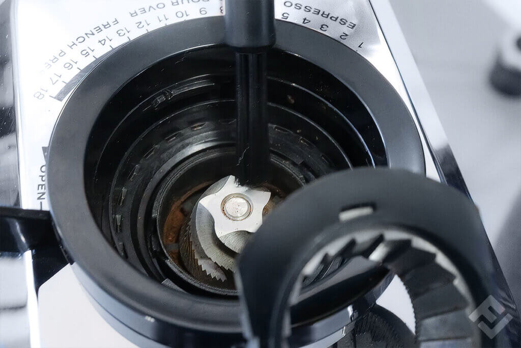 View on the grinder unit of a De'Longhi electric coffee grinder after removing the coffee bean container