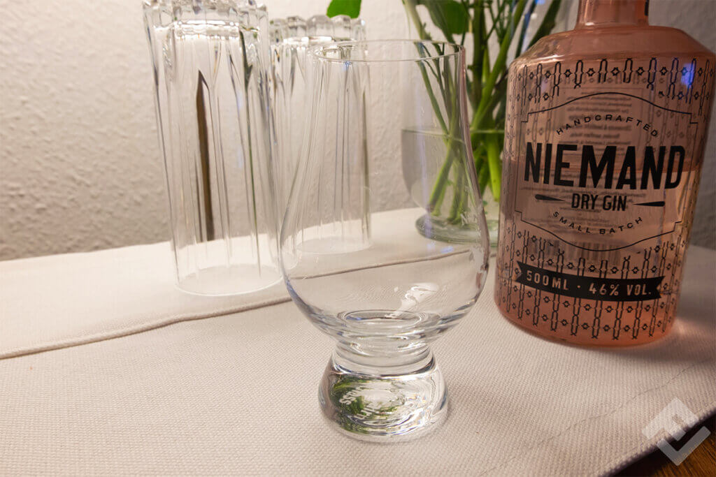 Niemand Gin and a nosing glass on a table.