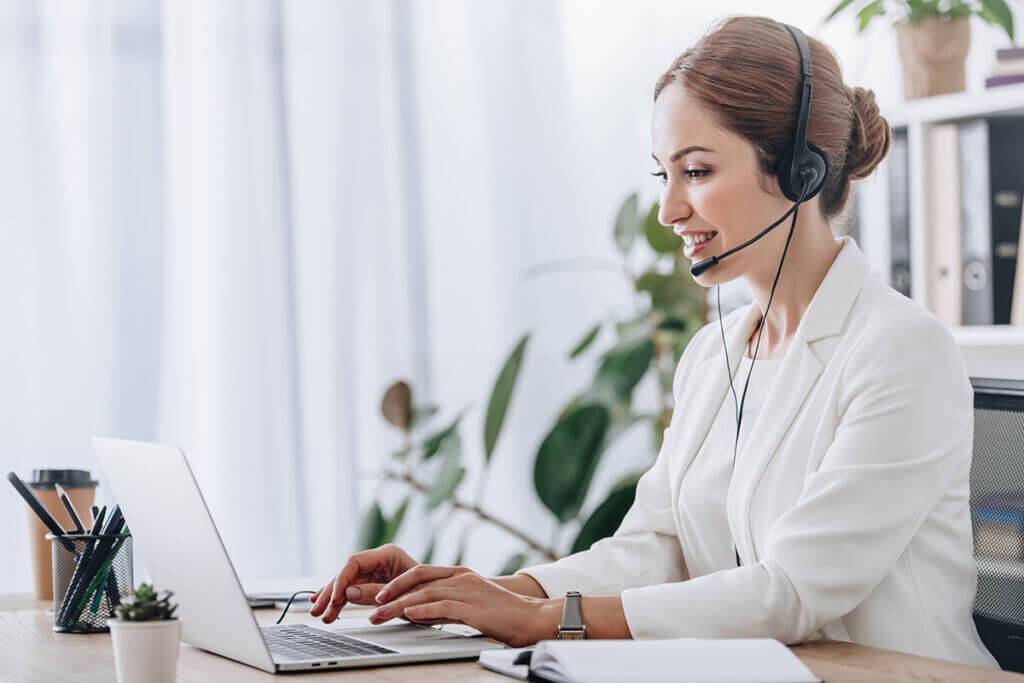 woman works with headset on laptop