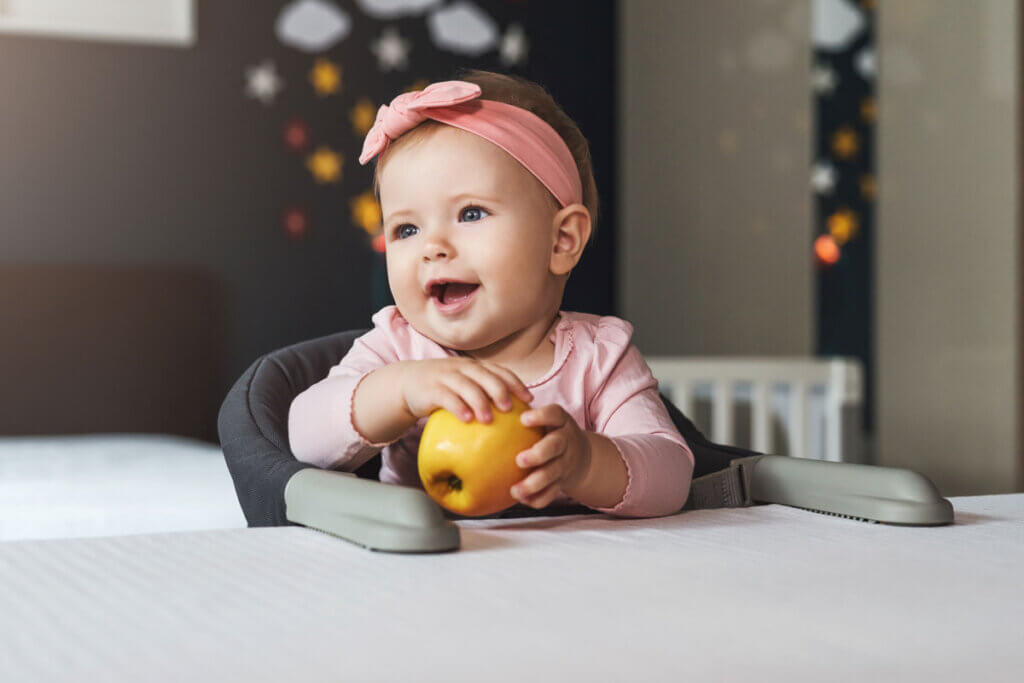 happy little girl on a child's high chair