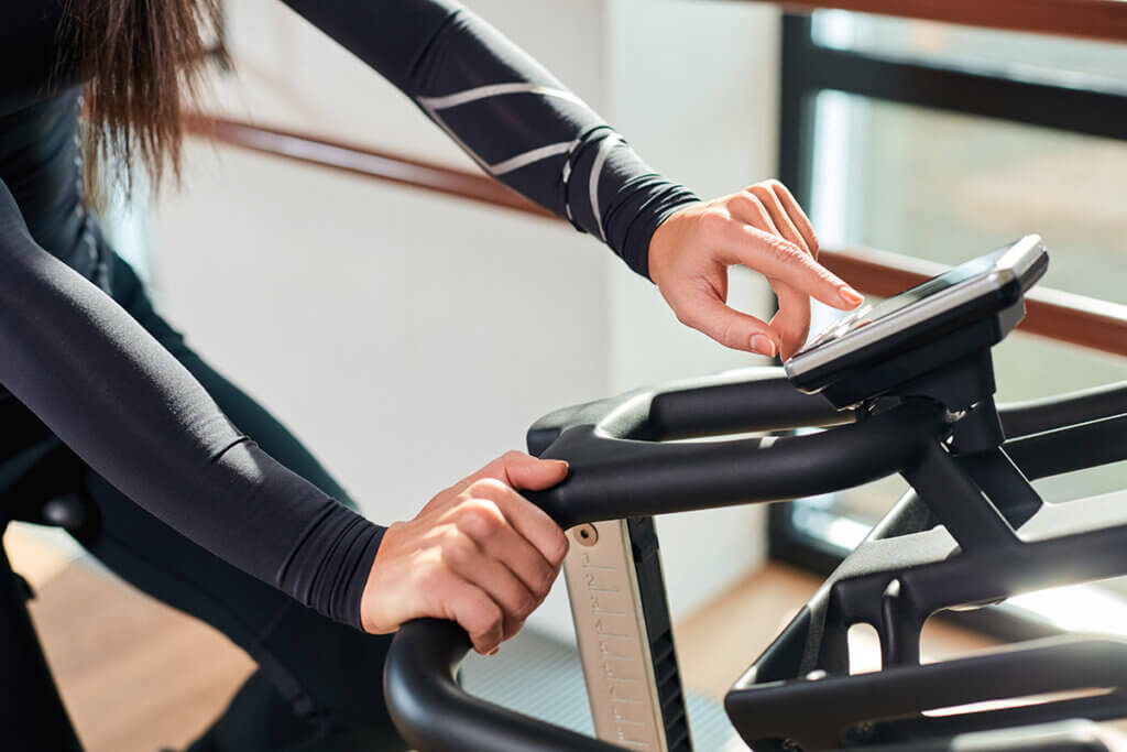 woman exercising adjusts indoor bike