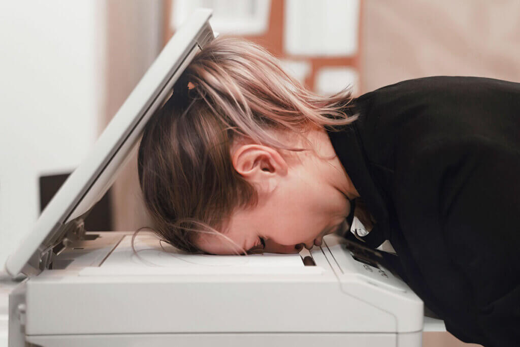 Woman presses head on printer