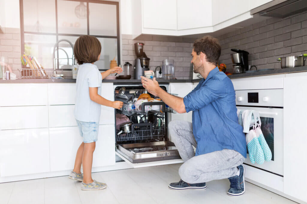 Father and child put the dishwasher away