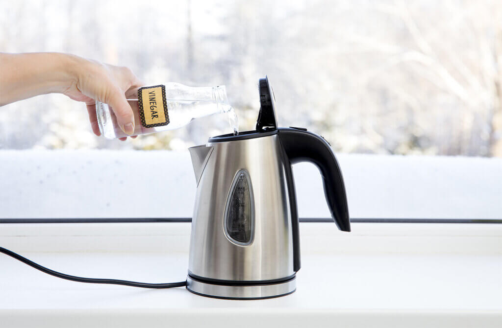 woman cleans kettle with vinegar