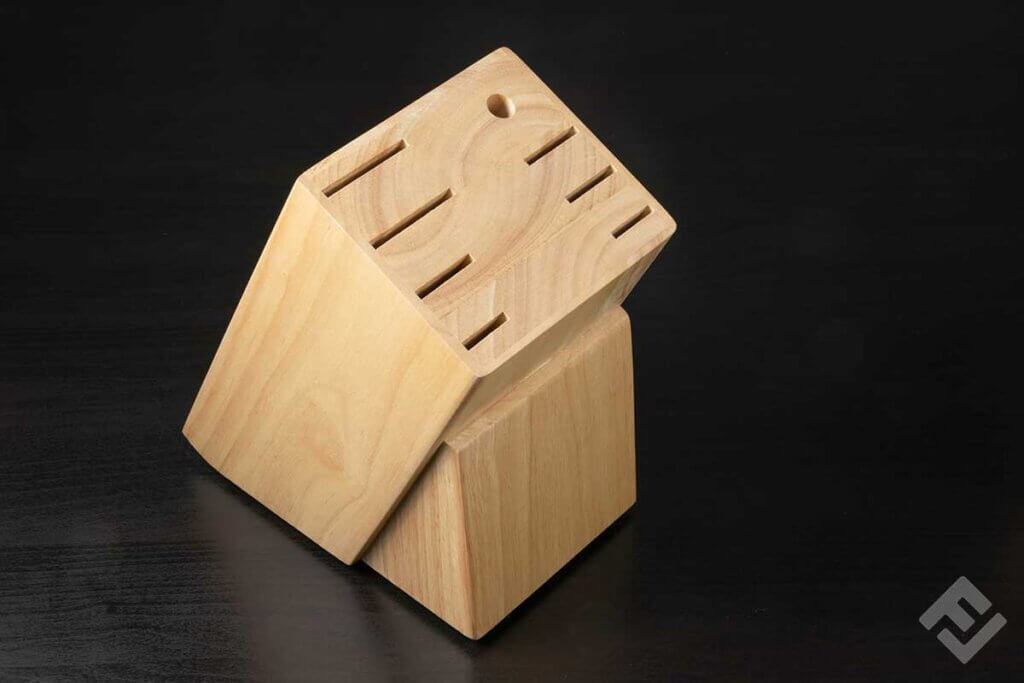 Empty wooden knife block against a black background