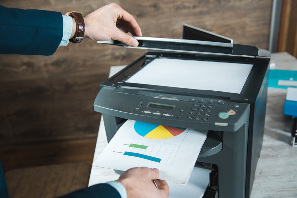 You pull printed paper out of a multifunction printer and open the cover of the scan support.