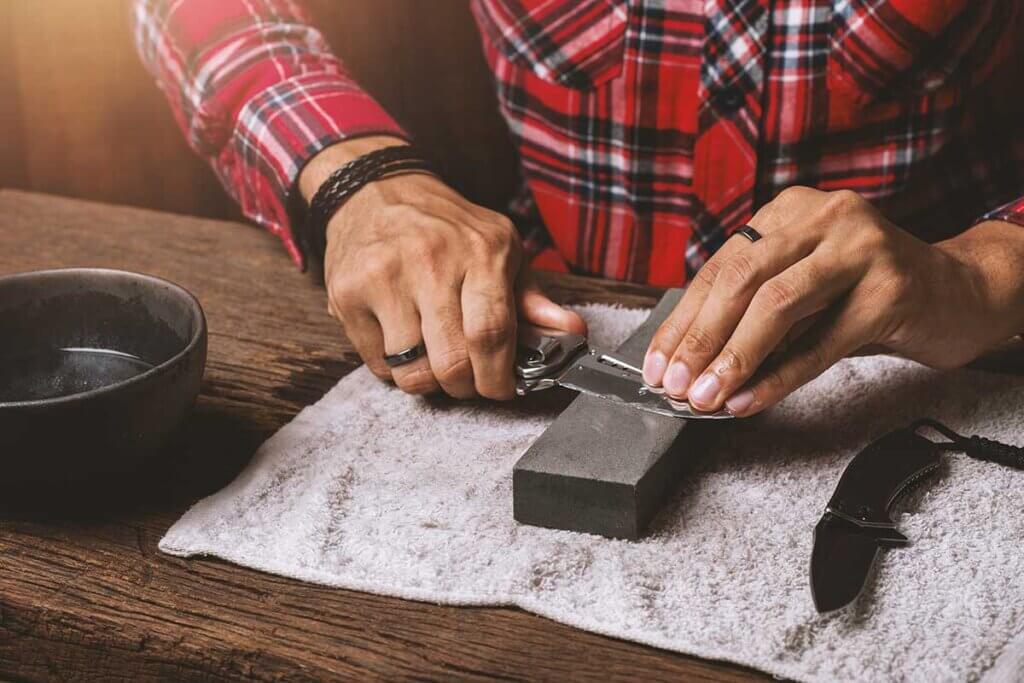 man_sharpening_blades_on_whetstone