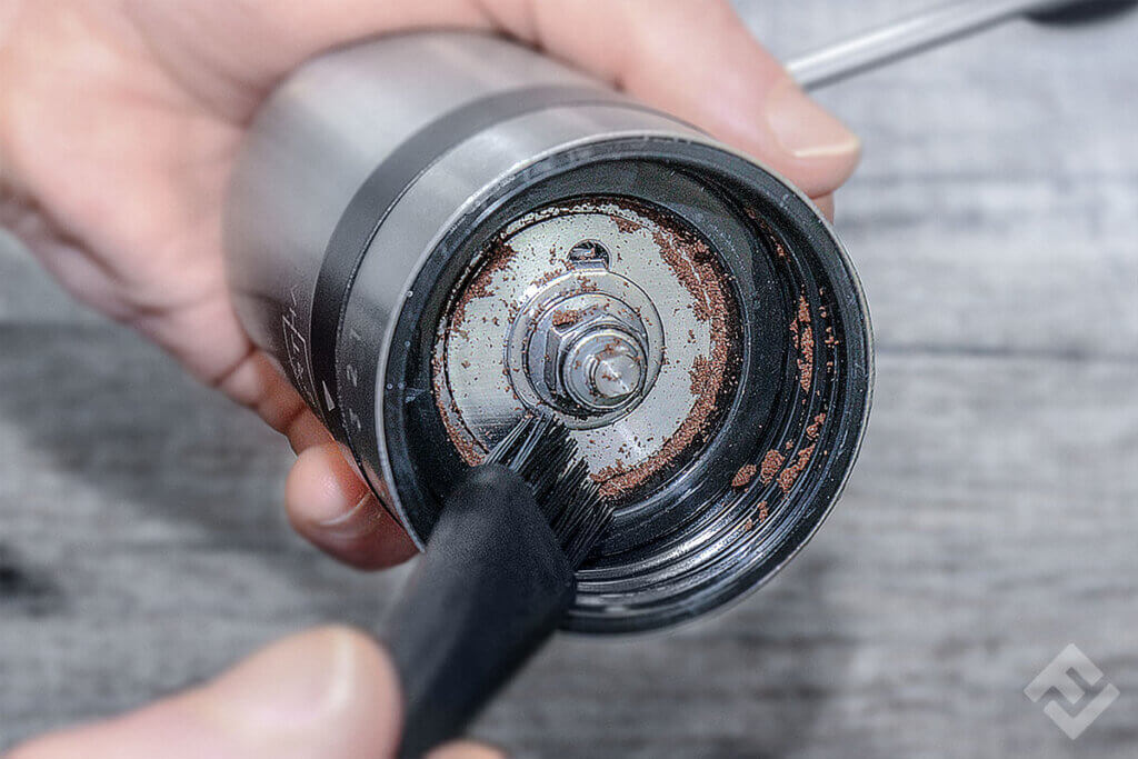 Silberthal manual coffee grinder being cleaned with a brush.