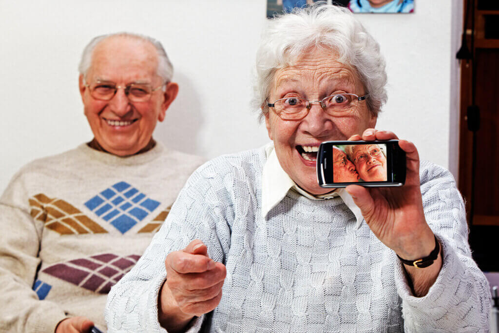 Seniors with smartphones smile