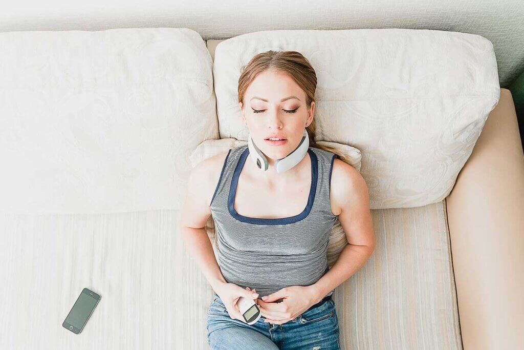 Woman lying on the couch with neck massager