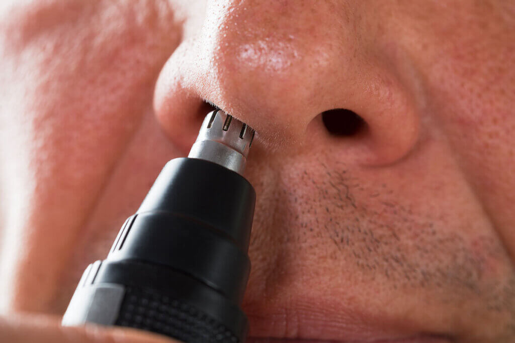 Close-up man trimming nose hair