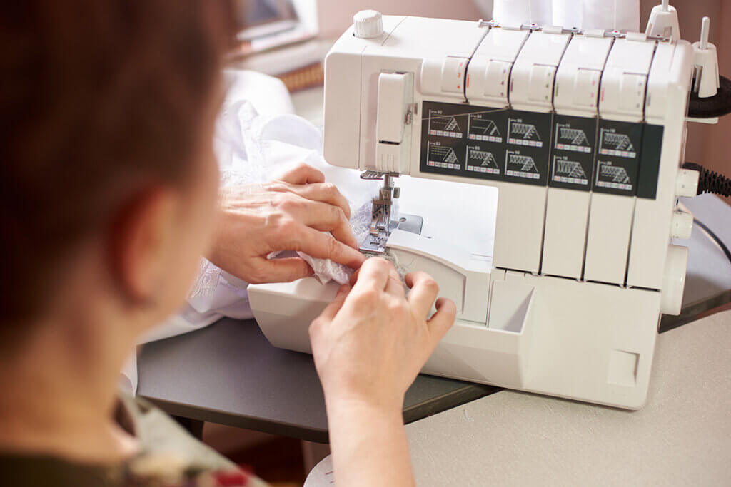 overlocker older woman at machine sewing