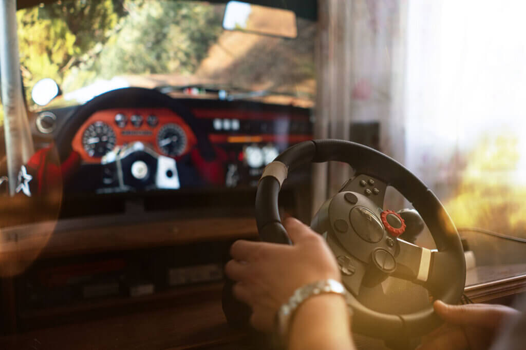 Man plays racing game with steering wheel