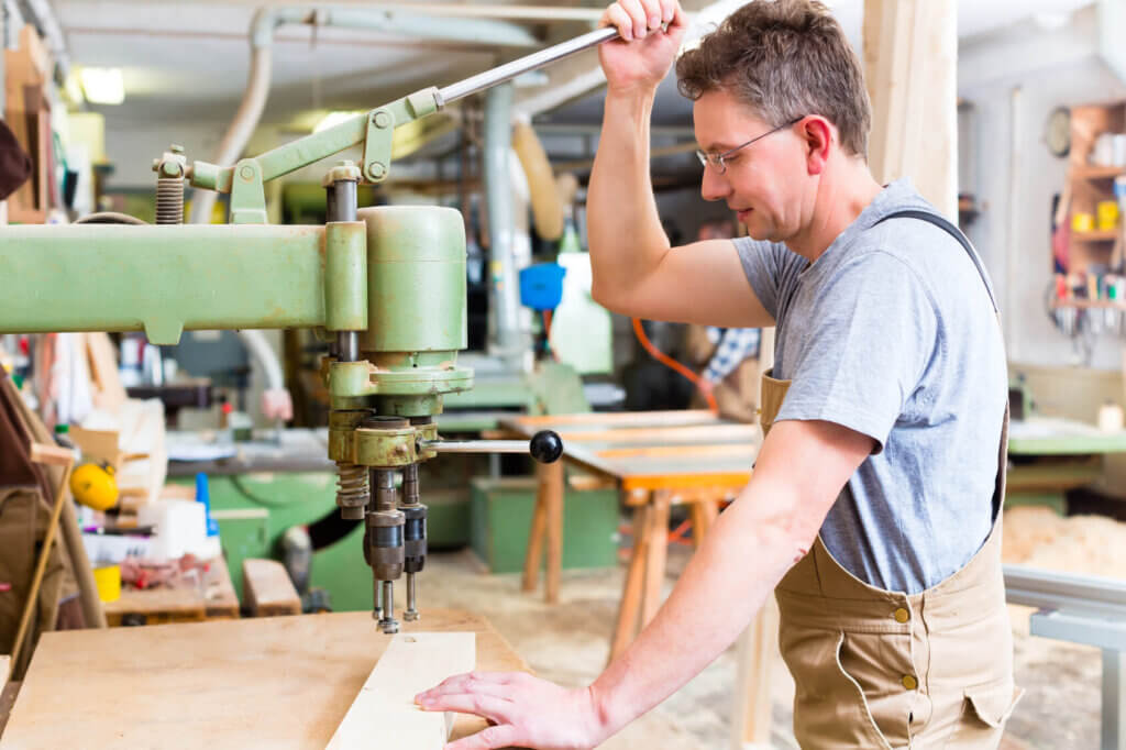 man works with pillar drill