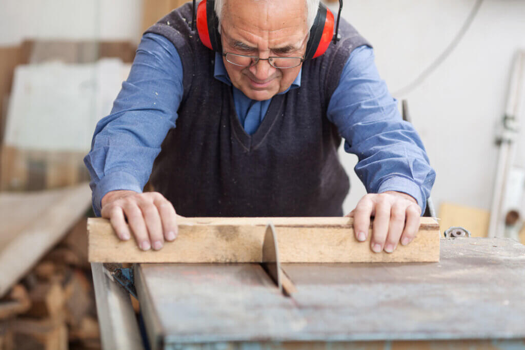 Man sawing wood with table saw