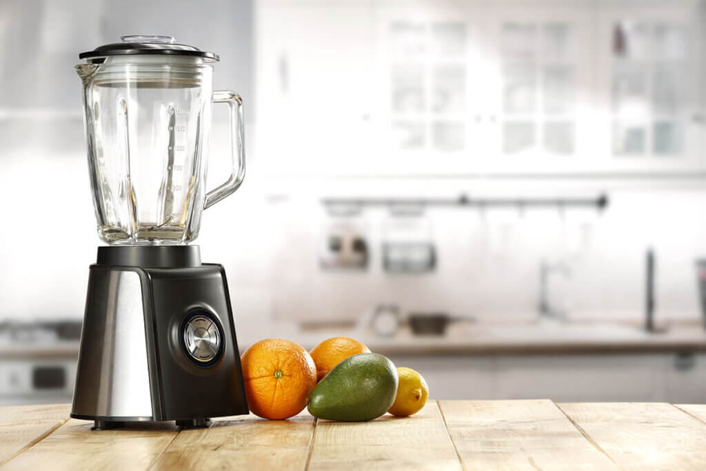 Blender on a table with fruit