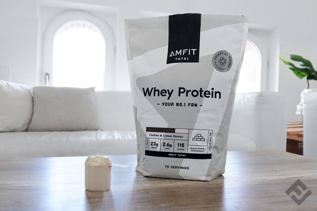 Bag of Amfit Nutrition Total whey powder Cookies and Cream with a scoop.