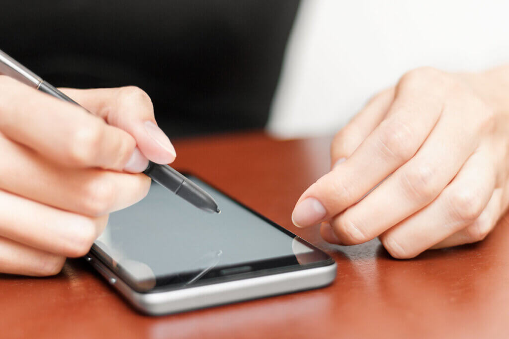 Woman operates smartphone with stylus