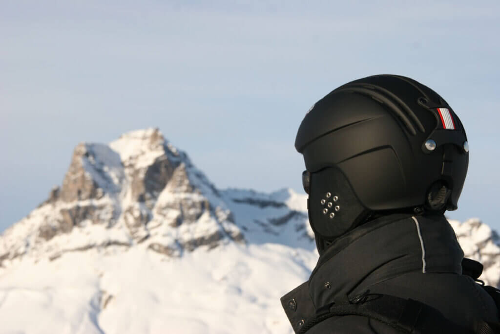 Person wears ski helmet in mountains