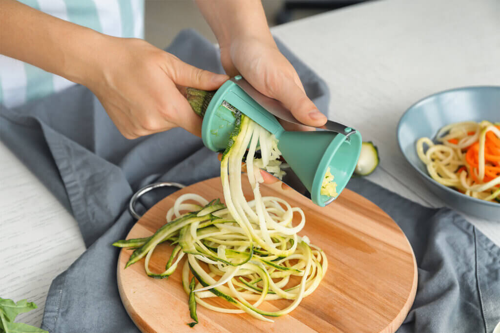 person uses spiraliser in the kitchen