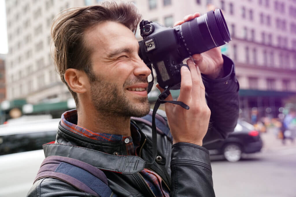 man photographing with system camera