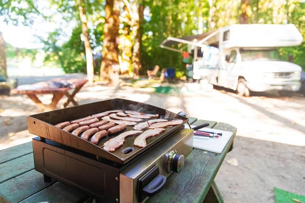 sausages and ham are prepared on the grill