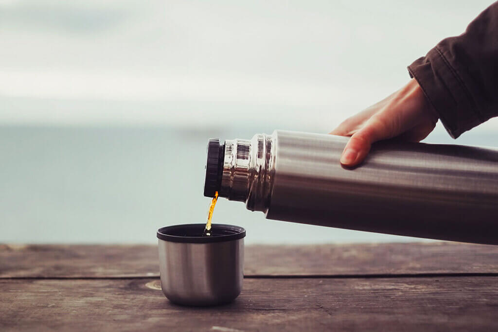 traveler pours coffe on the way