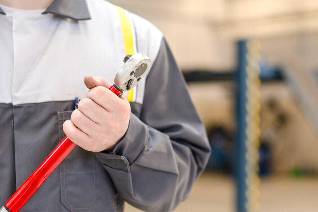 man holding a red torque wrench