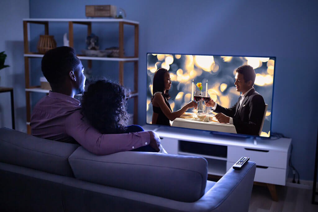 couple on sofa looking at tv