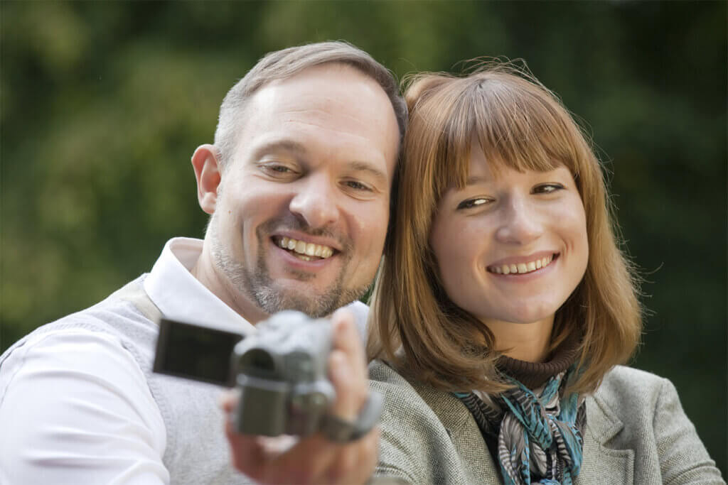 Couple looks into video camera together