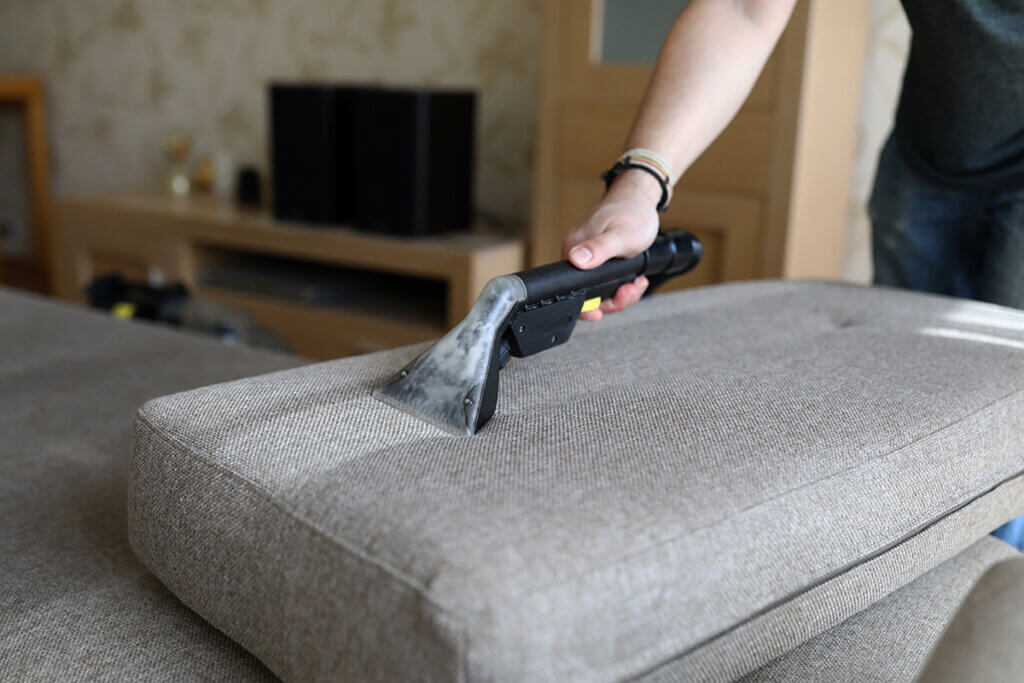  person cleans the sofa in the living room