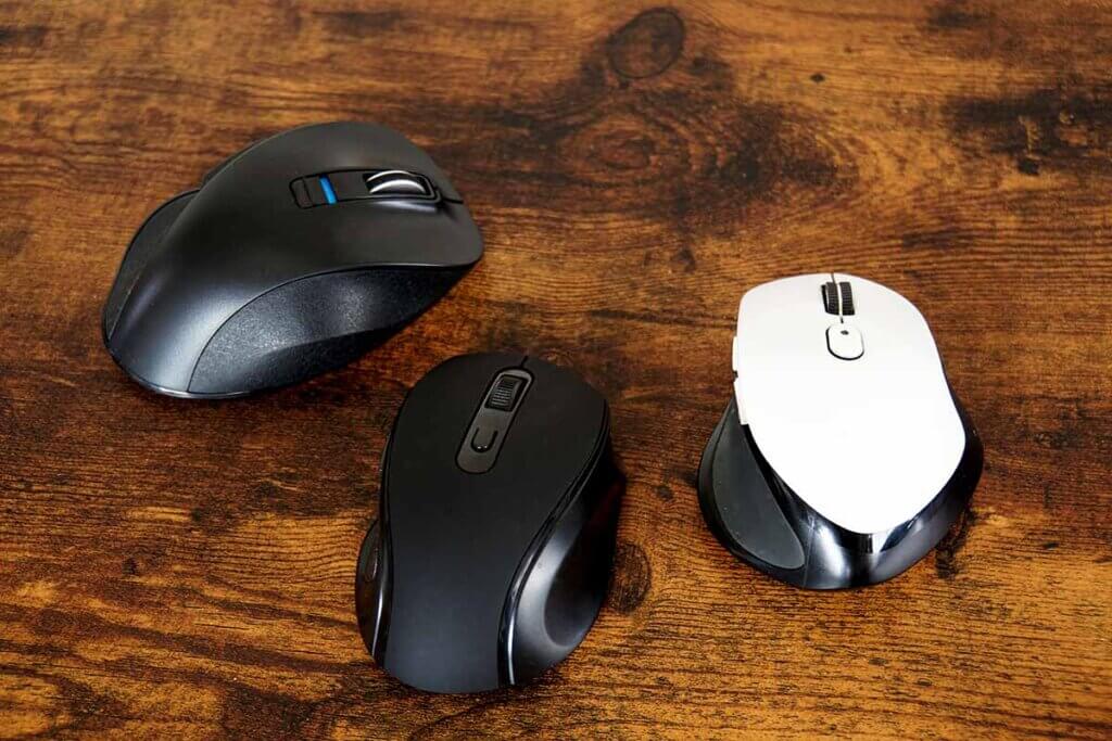 three wireless mice on a wooden table